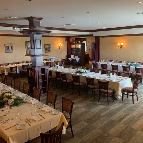 Luciano's Ristorante & Lounge dining room with multiple long tables set for a banquet.
