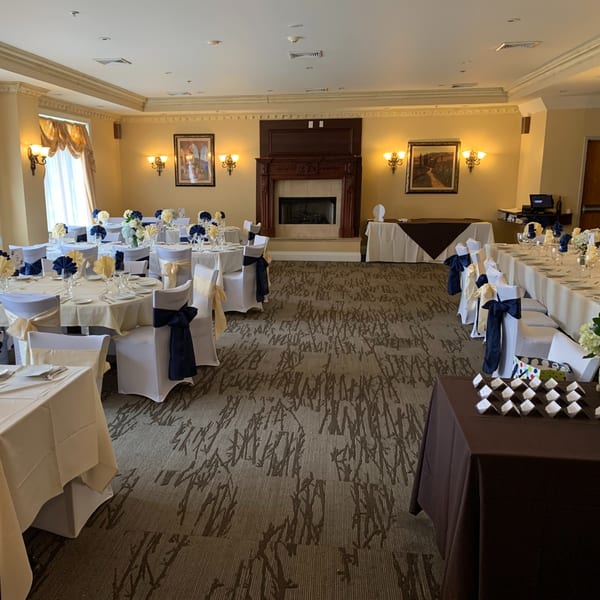Elegant Luciano's Ristorante & Lounge dining room set with white and blue decor for an event.