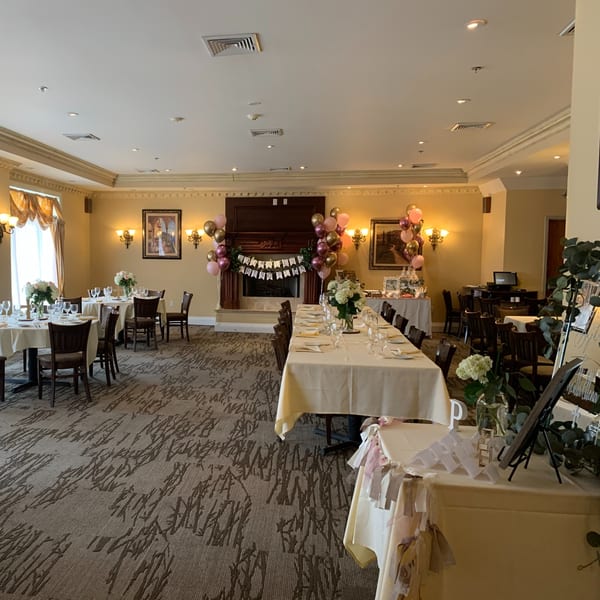A Luciano's Ristorante dining room set for a celebration with decorated tables and balloons.