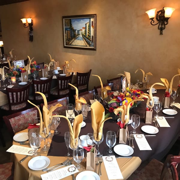 Tables set for a banquet at Luciano's Ristorante, featuring elegant place settings and floral centerpieces.