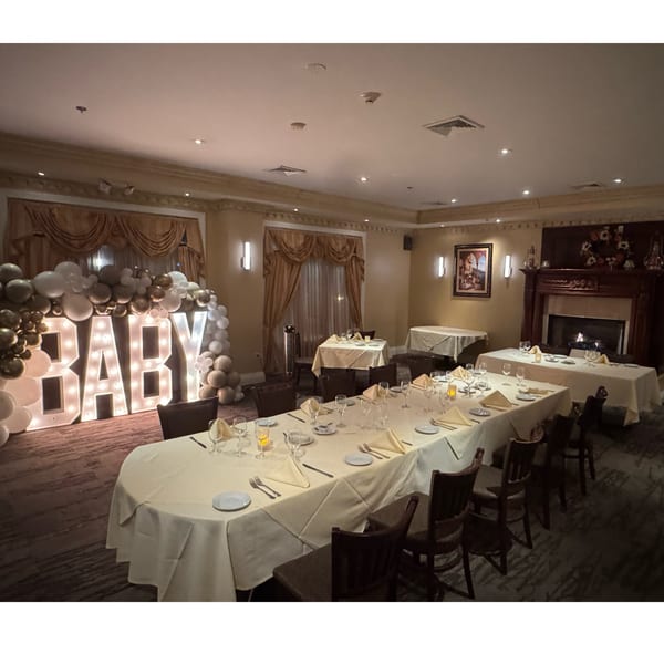Luciano's Ristorante & Lounge dining room set for a baby shower with "BABY" marquee letters.