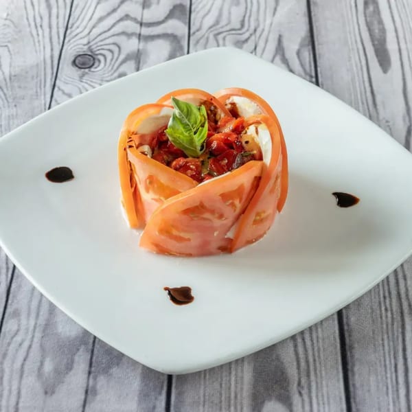 Luciano's Ristorante & Lounge's Italian caprese salad with tomato slices, mozzarella, basil, and balsamic glaze.
